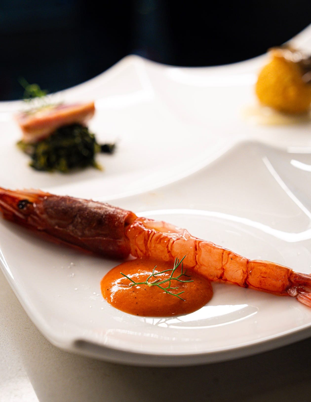 Gambero rosso al vapore, bisque densa, finocchietto e accompagnamento croccante.